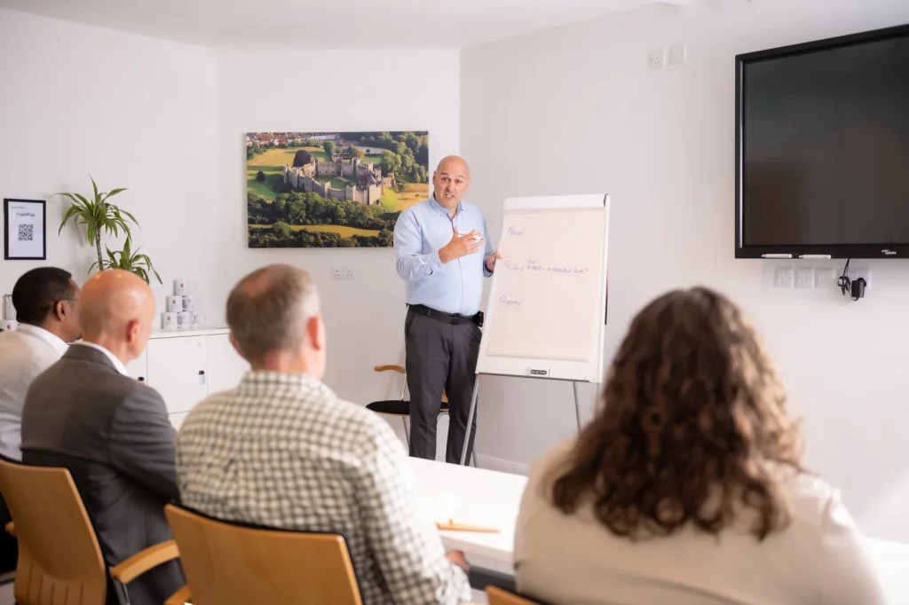 Colin Tapscott leading a workshop and presenting at a flip chart to a small group